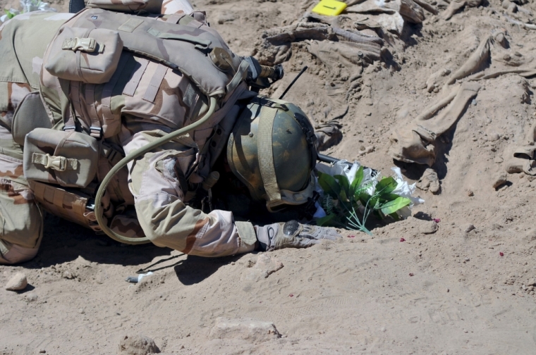 A soldier prays at a mass grave for Shiite soldiers from Camp Speicher who have been killed by Islamic State militants in the presidential compound of the former Iraqi president Saddam Hussein in Tikrit, April 6, 2015. Iraqi forensic teams began on Monday excavating 12 suspected mass grave sites thought to hold the corpses of as many as 1,700 soldiers massacred last summer by Islamic State militants as they swept across northern Iraq.