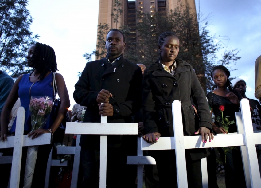 People hold wooden crosses, symbolizing the people killed by gunmen at Garissa University College, as they pray during a memorial vigil at the 