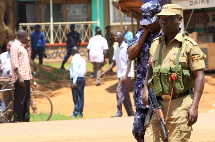 An Ugandan policeman holds his weapon during an arrest of people suspected of murdering Joan Kagezi, a senior Ugandan prosecutor, on the outskirts of Uganda's capital Kampala, April 7, 2015. Kagezi was shot dead late on March 30, in what police said could be a targeted assassination connected to her prosecution of suspects in twin bombings in the capital Kampala claimed by the Somali Islamist rebel group al-Shabaab.