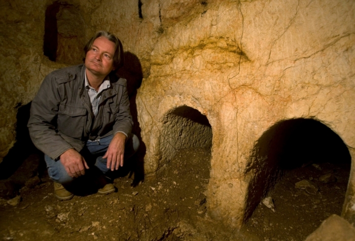 Archaeologist Shimon Gibson kneels inside a burial cave on the edge of Jerusalem's Old City, December 16, 2009, where Israeli archaeologists have said that they unearthed shroud remains from the Jesus-era, in 2000. According to Gibson, the shroud pieces, dating back to the first century A.D., suggest that the Turin Shroud, hitherto assumed to be the one used to wrap the body of Jesus, was woven in a much later period.