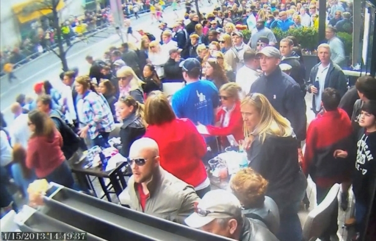 A still image captured from surveillance video at the Boston Marathon shows the scene moments before a second bomb exploded as a man, marked with a circle by prosecutors (top R) and identified by them as defendant Dzhokhar Tsarnaev, moves rapidly away from the spot near the finish line of the race on April 15, 2013, in this handout video provided by the U.S. Attorney's Office in Boston, Massachusetts on March 9, 2015. Accused bomber Tsarnaev, 21, is accused of killing three people and injuring 264, at the Boston Marathon's crowded finish line on April 15, 2013. This is the first image of a four-picture series.