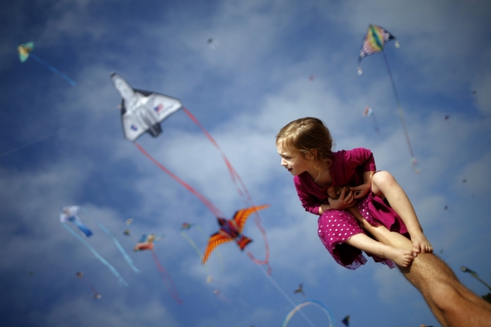 Madeleine Klonoski, 2, sits on her father's leg at a kite festival in Redondo Beach, California March 8, 2015.