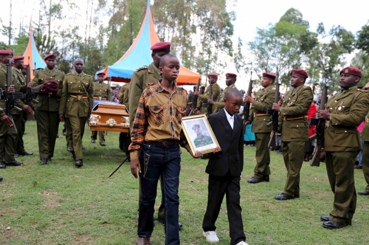 The sons of Corporal Benard Kipkemoi Tonui, a Kenya Police from the elite Recce Company squad who was killed as he battled gunmen that attacked Garissa University, carry his picture during his funeral in the village of Cheleget in Bomet, April 11, 2015. Kenya has given the United Nations three months to remove a camp housing more than half a million Somali refugees, as part of a get-tough response to the killing of 148 people by Somali gunmen at a Kenyan university.