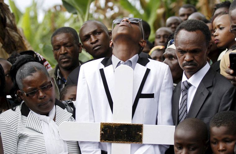 Samuel Kimata (C) flanked by his mother Regina Nyambura and father Raphael Githakwa mourn as they carry the coffin containing the body of Angela Nyokabi, a student killed during an attack by gunmen at Garissa University, in Wanugu village, Gatundu near Kenya's capital Nairobi April 10, 2015. Days after Islamists killed 148 people at Garissa university, Kenya's president held out an olive branch to Muslims and urged them to join Nairobi in the struggle against militant Islam by informing on sympathizers.