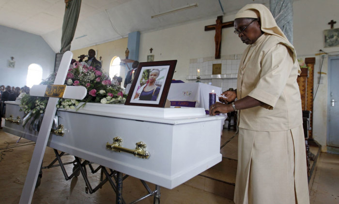 A Catholic nun lights a candle on top of the coffin containing the body of Angela Nyokabi, a student killed during an attack by gunmen at Garissa University, at Matunguru Parish in Gatindu, near the capital Nairobi April 10, 2015.