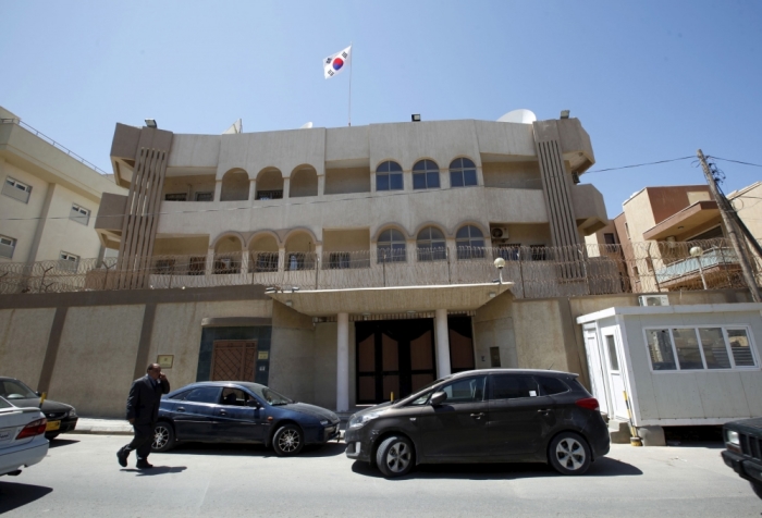 A man walks past the South Korean embassy after it was attacked by gunmen in Tripoli April 12, 2015. Unidentified gunmen fired shots at the South Korean embassy in the Libyan capital Tripoli on Sunday killing two local security guards, South Korean and Libyan officials said.