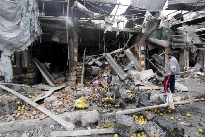 A man inspects the damage from what activists said was due to shelling by warplanes loyal to Syria's president Bashar Al-Assad inside a vegetable market in the al-Maadi neighbourhood of Aleppo April 11, 2015.