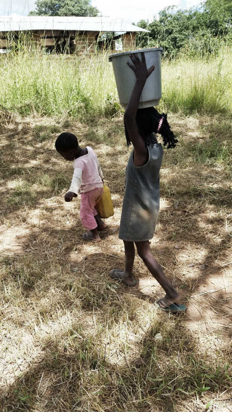 Sisters Carry water in Bulanda, Zambia
