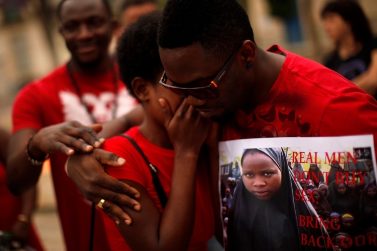 A Nigerian woman is comforted by a man as they take part in a protest, called by Malaga's Nigerian women Association, for the release of the abducted secondary school girls from the remote village of Chibok in Nigeria, at La Merced square in Malaga, southern Spain, May 13, 2014. The leader of the Nigerian Islamist rebel group Boko Haram has offered to release more than 200 schoolgirls abducted by his fighters last month in exchange for its members being held in detention, according to a video posted on YouTube on Monday.