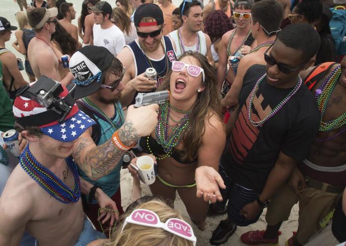 A squirt gun is used to spray alcohol into a party-goers mouth during spring break festivities in Panama City Beach, Florida, March 12, 2015. Unwilling to evict spring break, a crucial season in a community where tourism brings in more than 640 billion annually, the city has passed new rules to counter the worst excesses. Bars must stop serving alcohol at 2 a.m. in March, two hours earlier than before.