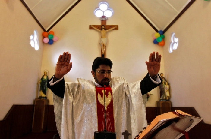 A priest conducts a mass at a Catholic church during Christmas celebrations in Srinagar, December 25, 2012.