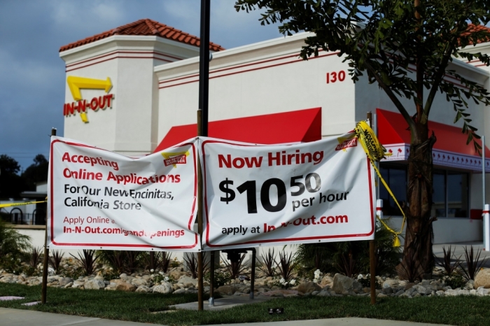A sign posted out in front of a newly constructed In-N-Out fast food restaurant advertises for workers with a salary of .50 per hour, in Encinitas, California, May 7, 2014.