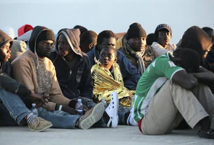 Migrants rest after they disembarked in the Sicilian harbour of Augusta, April 16, 2015.