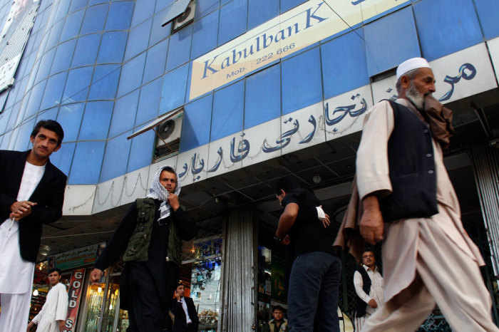 Afghan people walk past a Kabulbank branch in Kabul September 14, 2010. Afghanistan's central bank has stepped in to take control of the troubled Kabulbank, its governor said on Tuesday, after suspected irregularities raised concerns over the country's top private financial institution.