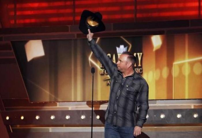 Musician Garth Brooks waves while on stage at the 49th Annual Academy of Country Music Awards in Las Vegas, Nevada April 6, 2014.