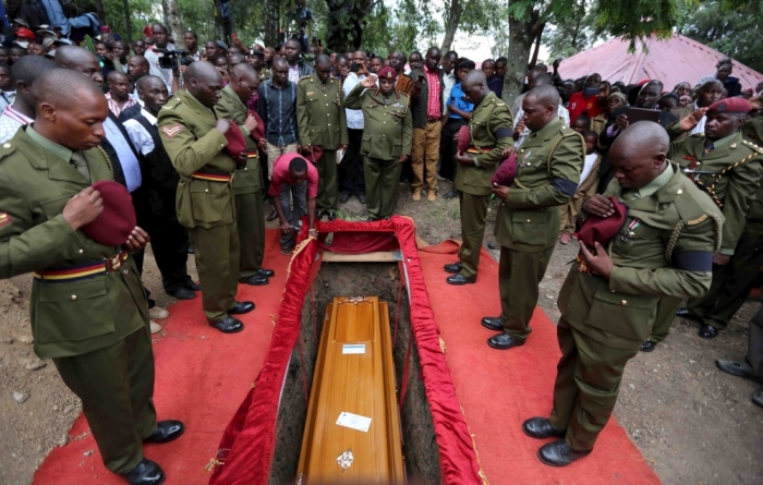 Kenya Police from the elite Recce Company squad pay their respects as the coffin is lowered into the grave at the funeral of Corporal Benard Kipkemoi Tonui, who was killed as he battled gunmen that attacked Garissa University, in the village of Cheleget in Bomet, April 11, 2015. Kenya has given the United Nations three months to remove a camp housing more than half a million Somali refugees, as part of a get-tough response to the killing of 148 people by Somali gunmen at a Kenyan university.