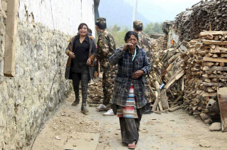 Residents cry as they walk past damaged houses to safer areas, after a 7.9 magnitude earthquake hit Nepal, in Gyirong county of Xigaze Prefecture, Tibet Autonomous Region, China, April 25, 2015. Rescuers dug with their bare hands and bodies piled up in Nepal on Sunday after an earthquake devastated the heavily crowded Kathmandu valley, killing at least 1,900, and triggered a deadly avalanche on Mount Everest. In Tibet, the death toll climbed to 17, according to a tweet from China's state news agency, Xinhua. Picture taken April 25, 2015.