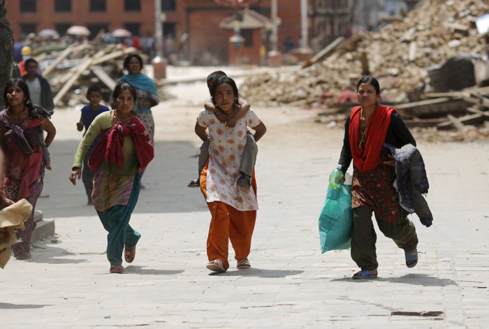 People rush for safety during a strong aftershock after an earthquake, in Kathmandu, Nepal April 26, 2015.