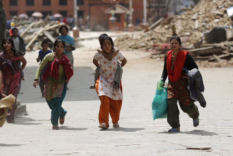 People rush for safety during a strong aftershock after an earthquake, in Kathmandu, Nepal April 26, 2015. Rescuers dug with their bare hands and bodies piled up in Nepal on Sunday after the earthquake devastated the heavily crowded Kathmandu Valley, killing more than 2,200 people, and triggered a deadly avalanche on Mount Everest.