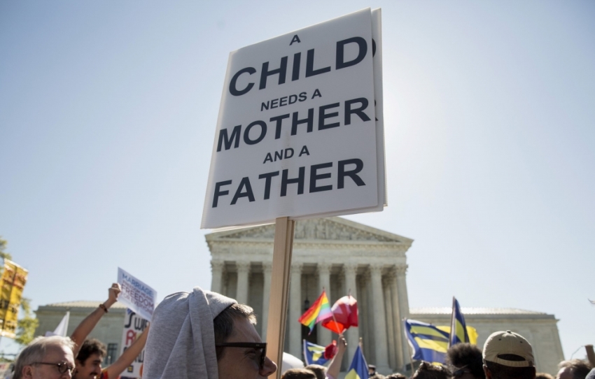 A protester holds a sign against same sex marriage in front of the Supreme Court before the court hears arguments about gay marriage in Washington, April 28, 2015. The nine justices of the Supreme Court began on Tuesday to hear arguments on whether the Constitution provides same-sex couples the right to marry, taking up a contentious social issue in what promises to be the year's most anticipated ruling.