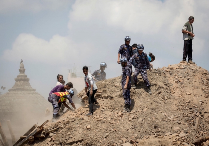 Nepalese police personnel and volunteers clear the rubble while looking for survivors at the compound of a collapsed temple, following Saturday's earthquake, in Kathmandu, Nepal, April 27, 2015.