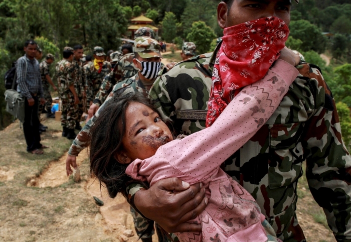 An injured girl is carried by a Nepal Army personnel to a helicopter following Saturday's earthquake in Sindhupalchowk, Nepal, April 28, 2015.