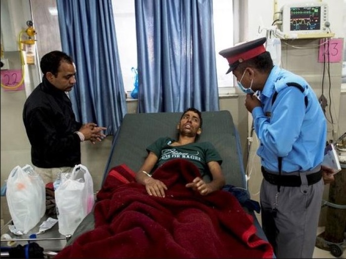 Rishi Khanal who was pulled out from a collapsed residential building following the April 25, 2015 earthquake, speaks to a security guard at a hospital in Kathmandu on Wednesday.