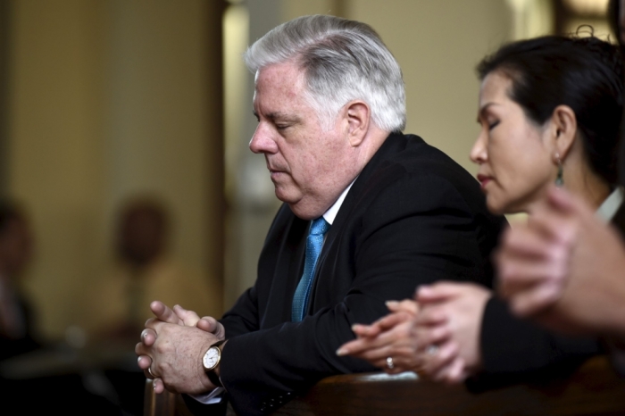 Governor Larry Hogan (L) and first lady Yumi Hogan pray at St. Peter Claver Catholic Church in Baltimore, Maryland, May 3, 2015. Baltimore's Mayor Stephanie Rawlings-Blake on Sunday lifted a 10 p.m. to 5 a.m. curfew she had imposed on the city last week after a night of looting and arson that followed the death of 25-year-old Freddie Gray from injuries suffered while in the police custody. Hogan called for a day of prayer and reconciliation on Sunday.
