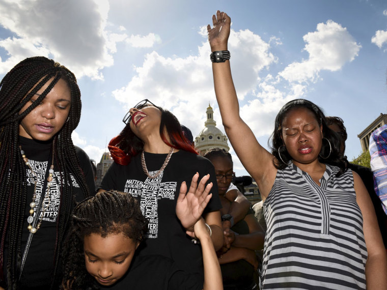 People pray during a religious rally for Freddie Gray in front of the City Hall in Baltimore, May 3, 2015. Baltimore's Mayor Stephanie Rawlings-Blake on Sunday lifted a night curfew imposed on the city last week to stem a spate of looting and arson that followed the funeral of 25-year-old black man Freddie Gray who died from injuries suffered while in police custody.