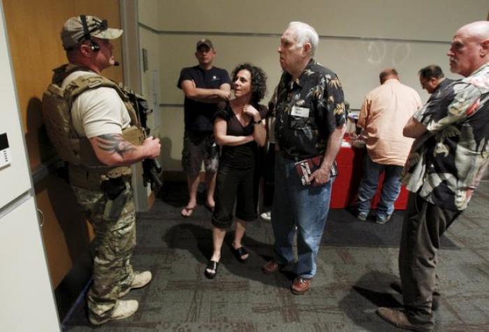 A police officer prevents attendees from leaving the Muhammad Art Exhibit and Contest after shots were fired outside the venue in Garland, Texas, May 3, 2015. Two gunman who opened fire on Sunday at the anti-Islam art exhibit featuring depictions of Muhammad were themselves shot dead at the scene, a local CBS television affiliate and other local media reported, citing Garland police.