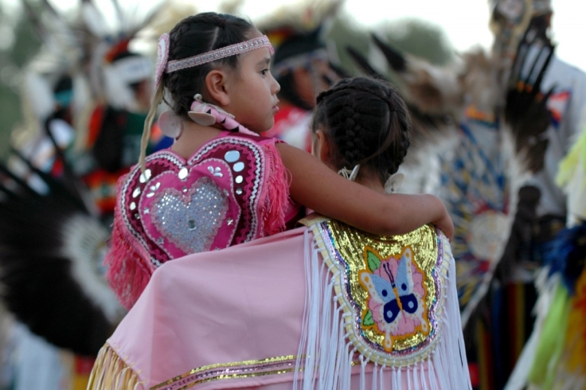 A pair of young Native American dancers stand together during the opening "grand entry" to start the Oglala Nation Pow Wow and Rodeo in Pine Ridge, South Dakota, August 4, 2006. The annual festival is a bright spot for the Pine Ridge Indian Reservation, which struggles with high unemployment and problems with substance abuse and gangs and is one of the poorest communities in the United States.