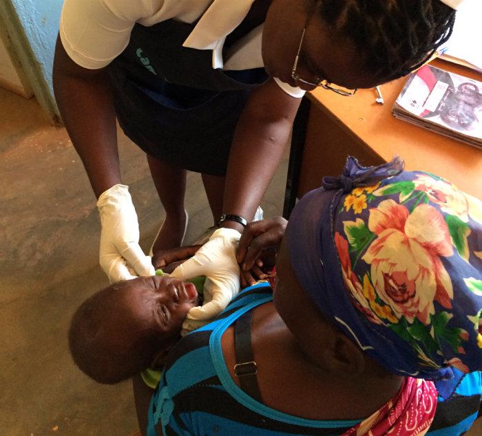 Nurse Bertha Himaanga examines a young child of an HIV-positive mother at the Moyo ADP Health Center on March 25, 2015, in Southern Zambia.