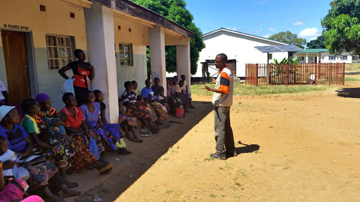 World Vision Zambia Communications Officer Collins Kaumba entertains some women waiting to visit the nurse at Moyo ADP Health Center in this photo taken on March 25, 2015.