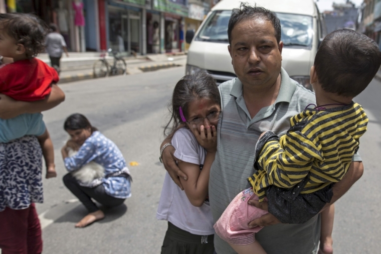 Local residents evacuate onto a street minutes after an earthquake in central Kathmandu, Nepal, May 12, 2015. At three people were killed and more than 300 injured in Nepal after a magnitude 7.3 earthquake shook the Himalayan nation on Tuesday, police said. The latest casualties came just weeks after a devastating quake, with a magnitude of 7.8, killed more than 8,000 people in Nepal and damaged hundreds of thousands of buildings.