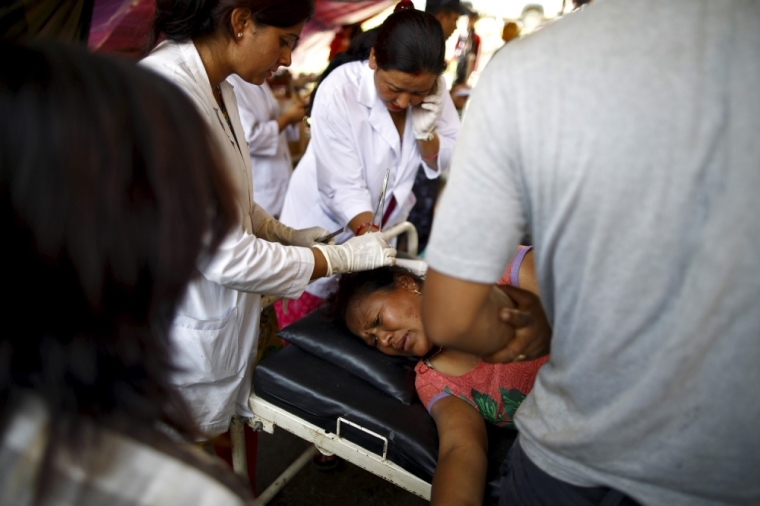 A woman injured in an earthquake gets a stitch in a field hospital at Sankhu, May 12, 2015. A fresh 7.3-magnitude earthquake struck Nepal on Tuesday, killing more than two dozen people in the Himalayan country and neighboring states, as many buildings already weakened by a much bigger quake last month were brought down. The earthquake was centered 68 kilometers (42 miles) west of the town of Namche Bazaar, close to Mount Everest and the border with Tibet, the U.S. Geological Survey said. It could be felt as far away as northern India and Bangladesh.