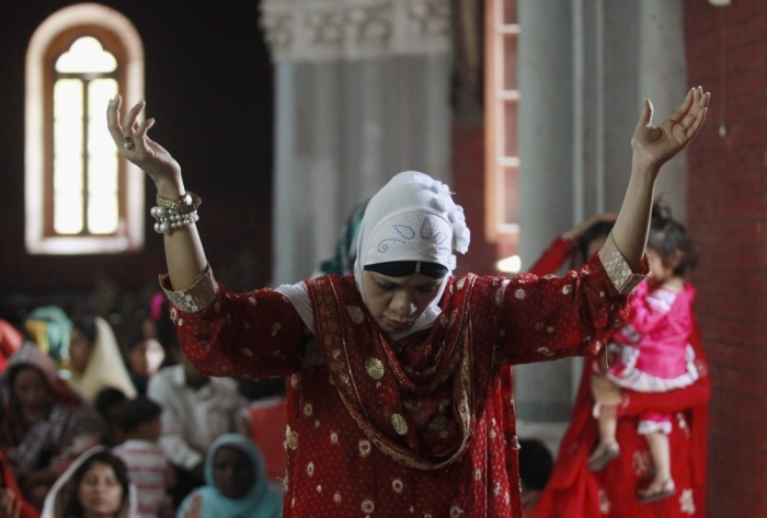 A Pakistani Christian woman prays along with others at the Sacred Heart of Jesus Church in Lahore, April 5, 2015.