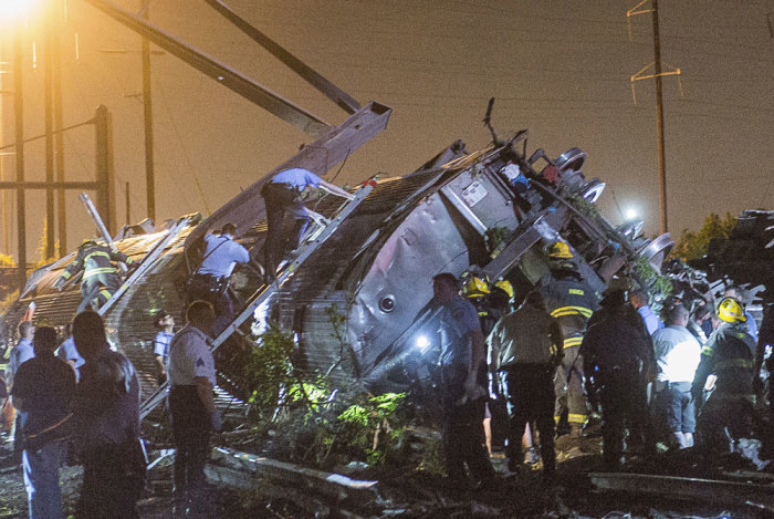 Rescue workers search for victims in the wreckage of a derailed Amtrak train in Philadelphia, Pennsylvania May 12, 2015. An Amtrak passenger train with more than 200 passengers on board derailed in north Philadelphia on Tuesday night, killing at least five people and injuring more than 50 others, several of them critically, authorities said. Authorities said they had no idea what caused the train wreck, which left some demolished rail cars strewn upside down and on their sides in the city's Port Richmond neighborhood along the Delaware River.