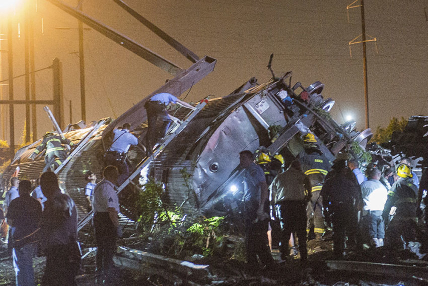 Rescue workers search for victims in the wreckage of a derailed Amtrak train in Philadelphia, Pennsylvania May 12, 2015. An Amtrak passenger train with more than 200 passengers on board derailed in north Philadelphia on Tuesday night, killing at least five people and injuring more than 50 others, several of them critically, authorities said. Authorities said they had no idea what caused the train wreck, which left some demolished rail cars strewn upside down and on their sides in the city's Port Richmond neighborhood along the Delaware River.