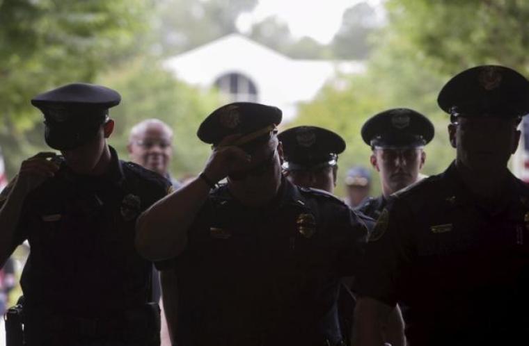 Policemen enter a building to attend a vigil service for two fellow officers killed during a traffic stop in Hattiesburg, Mississippi, May 11, 2015.