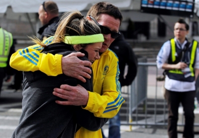 A woman is comforted by a man near a triage tent set up for the Boston Marathon after explosions went off at the 117th Boston Marathon in Boston, Massachusetts, April 15, 2013.