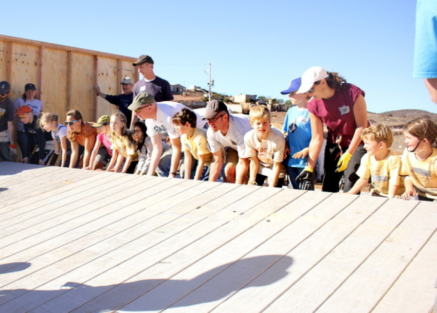Volunteers raising wall for a house as part of a "Homes for Hope" project.