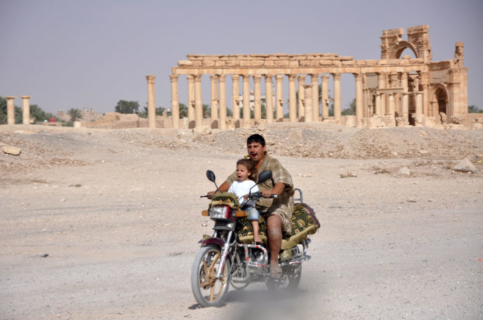 A man rides a motorcycle with a child in the historical city of Palmyra, September 30, 2010. Islamic State fighters in Syria have entered the ancient ruins of Palmyra after taking complete control of the central city, but there are no reports so far of any destruction of antiquities, a group monitoring the war said on May 21, 2015. Picture taken September 30, 2010.