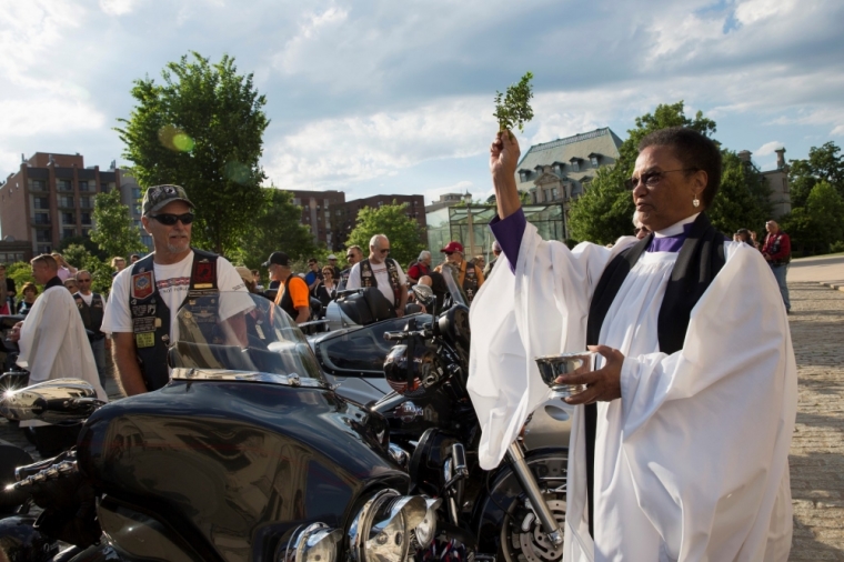 Rev. Nan Peete blesses motorcycles belonging to members of Rolling Thunder during the 'Blessing of the Bikes' ceremony at National Cathedral in Washington, May 23, 2014. National Cathedral welcomed members of Rolling Thunder XXVII ahead of their annual ride on the Memorial Day weekend.