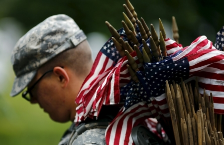 A member of the Third U.S. Infantry Regiment (The Old Guard) takes part in a "Flags-In" ceremony, ahead of Memorial Day, at Arlington National Cemetery in Washington, May 21, 2015. In advance of Memorial Day, soldiers of the 3rd U.S. Infantry Regiment (The Old Guard) place American flags at the foot of more than 228,000 graves during the annual "Flags-In" ceremony at Arlington National Cemetery."