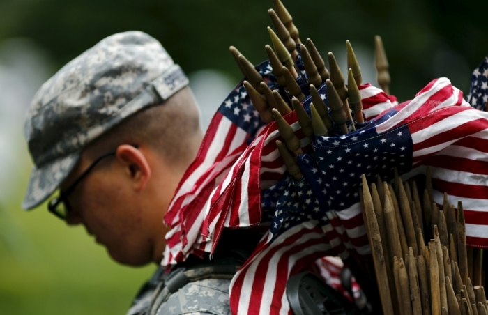 A member of the Third U.S. Infantry Regiment (The Old Guard) takes part in a 'Flags-In' ceremony, ahead of Memorial Day, at Arlington National Cemetery in Washington, May 21, 2015. In advance of Memorial Day, soldiers of the 3rd U.S. Infantry Regiment (The Old Guard) place American flags at the foot of more than 228,000 graves during the annual 'Flags-In' ceremony at Arlington National Cemetery.'
