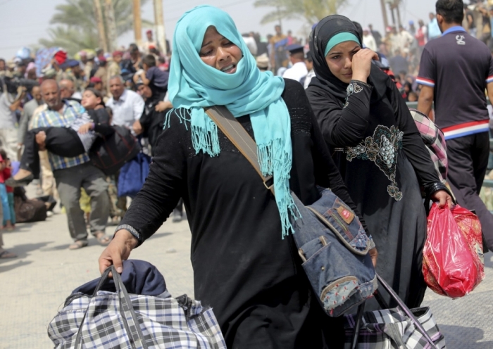 Displaced Sunni women fleeing the violence in Ramadi, carry bags as they walk on the outskirts of Baghdad, May 24, 2015. Iraqi forces recaptured territory from advancing Islamic State militants near the recently-fallen city of Ramadi on Sunday, while in Syria the government said the Islamists had killed hundreds of people since capturing the town of Palmyra.