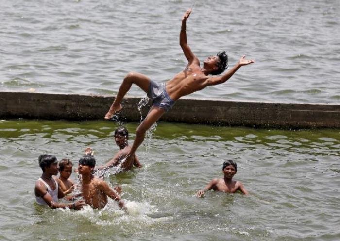 Boys cool off themselves in the waters of the river Sabarmati on a hot summer day in Ahmedabad, India, May 24, 2015.
