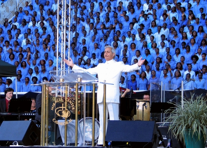 Televangelist Benny Hinn leads prayers at Uganda's national stadium in Kampala, Uganda, May 19, 2007. Wearing a white suit shimmering in the flood lights, the preacher promised a 'miracle crusade' to heal the sick, make the blind see and the lame walk.