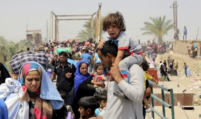 A displaced Sunni man fleeing the violence in Ramadi carries a crying child on his shoulders, on the outskirts of Baghdad, May 24, 2015. Iraqi forces recaptured territory from advancing Islamic State militants near the recently-fallen city of Ramadi on Sunday, while in Syria the government said the Islamists had killed hundreds of people since capturing the town of Palmyra.