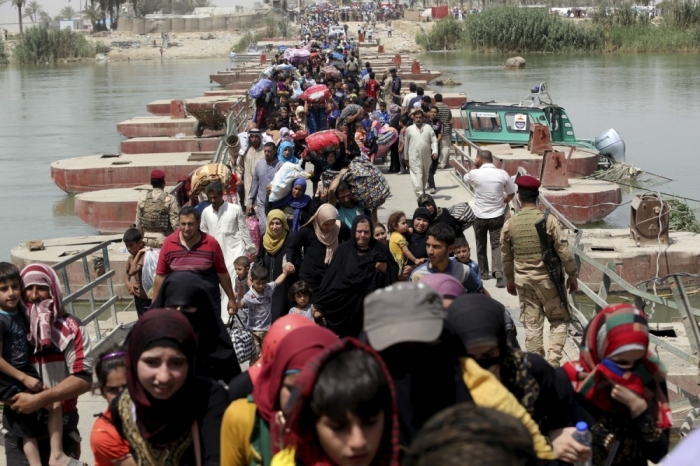 Displaced Sunni people fleeing the violence in Ramadi, cross a bridge on the outskirts of Baghdad, May 24, 2015. Iraqi forces recaptured territory from advancing Islamic State militants near the recently-fallen city of Ramadi on Sunday, while in Syria the government said the Islamists had killed hundreds of people since capturing the town of Palmyra.